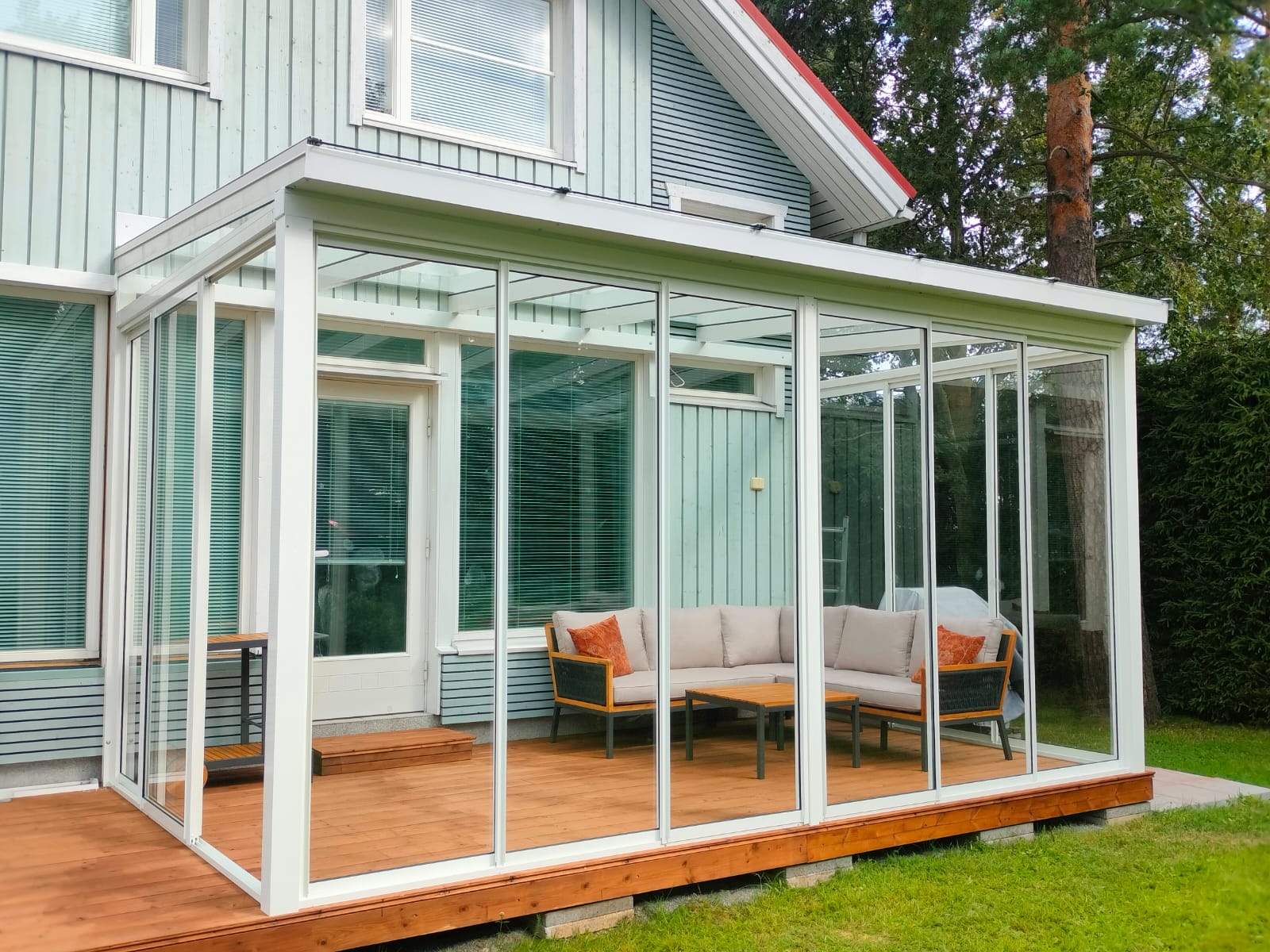 Moderni lasiterassi suomalaisessa metsässä iltahämärässä